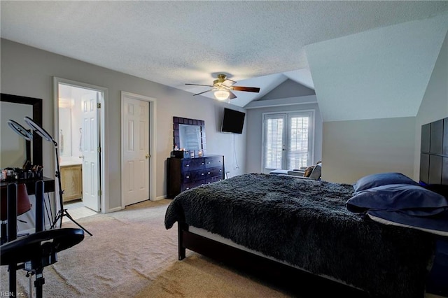 carpeted bedroom with a textured ceiling, ceiling fan, lofted ceiling, and ensuite bath