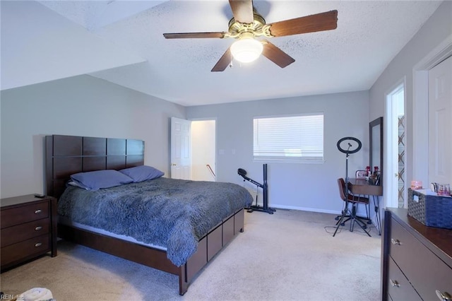 bedroom featuring a textured ceiling, ceiling fan, and light colored carpet