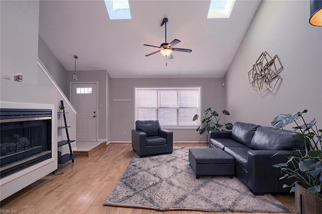 living room with ceiling fan, hardwood / wood-style flooring, and vaulted ceiling