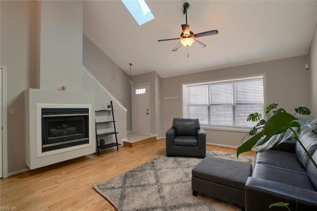 living room featuring ceiling fan, vaulted ceiling, and hardwood / wood-style flooring