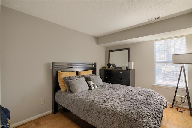 bedroom featuring wood-type flooring and multiple windows