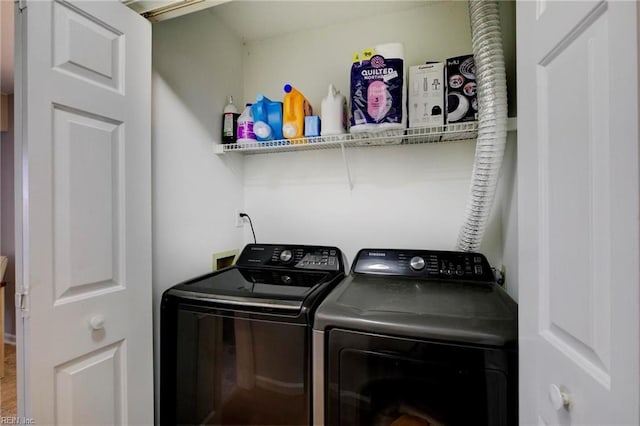 clothes washing area with washing machine and dryer