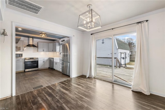 kitchen featuring crown molding, hanging light fixtures, appliances with stainless steel finishes, dark wood-type flooring, and wall chimney exhaust hood