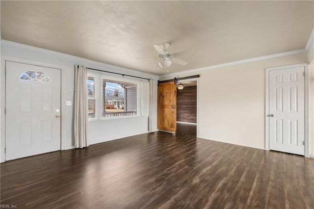 interior space with dark wood-type flooring, crown molding, a barn door, and ceiling fan