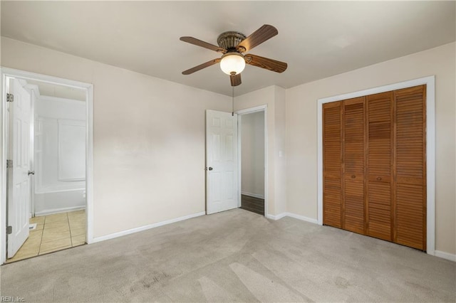 unfurnished bedroom with light carpet, ceiling fan, ensuite bathroom, and a closet