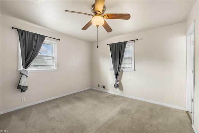 carpeted empty room featuring ceiling fan and plenty of natural light