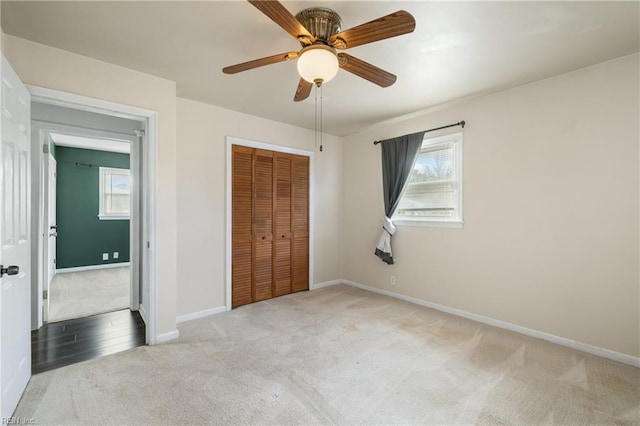 unfurnished bedroom featuring a closet, carpet floors, and ceiling fan