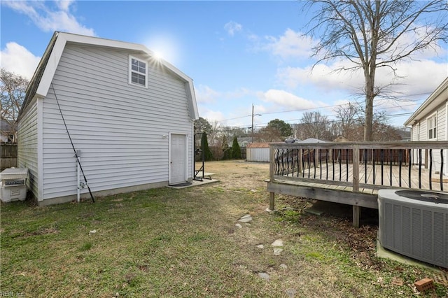 exterior space featuring a wooden deck, a lawn, and central air condition unit