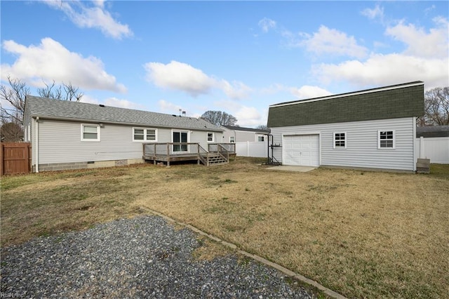 rear view of house featuring a deck, a garage, a lawn, and an outdoor structure