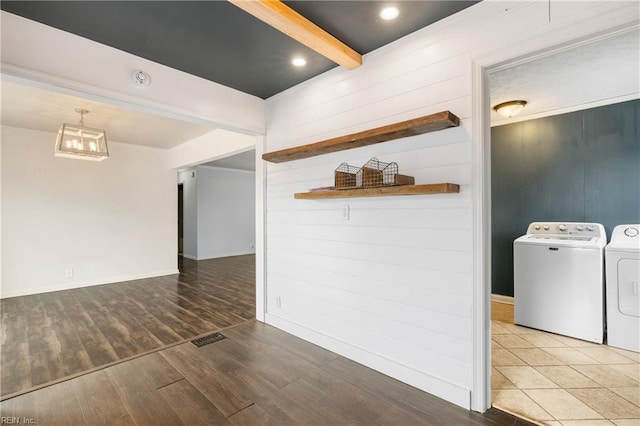 interior space with beamed ceiling, washing machine and clothes dryer, and hardwood / wood-style floors