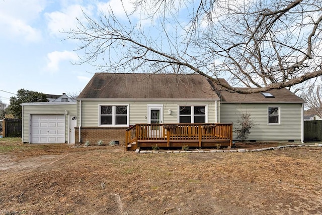 back of property with a deck, a yard, and a garage