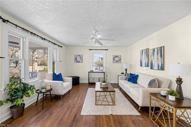 living room featuring ceiling fan, dark hardwood / wood-style floors, and a textured ceiling