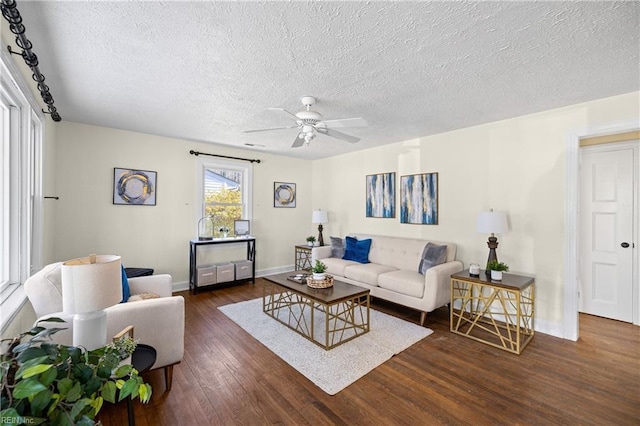 living room featuring ceiling fan, a textured ceiling, and dark hardwood / wood-style flooring