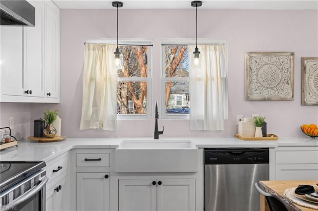 kitchen featuring wall chimney exhaust hood, decorative light fixtures, white cabinetry, sink, and stainless steel dishwasher