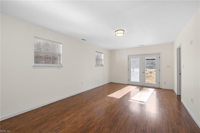 empty room featuring dark hardwood / wood-style floors and french doors