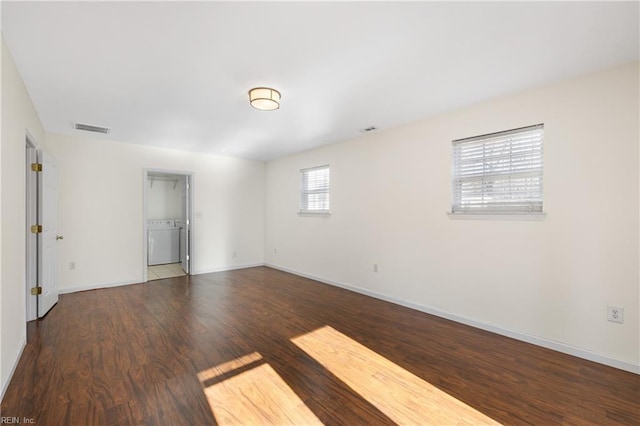 spare room featuring washer / clothes dryer and dark hardwood / wood-style floors