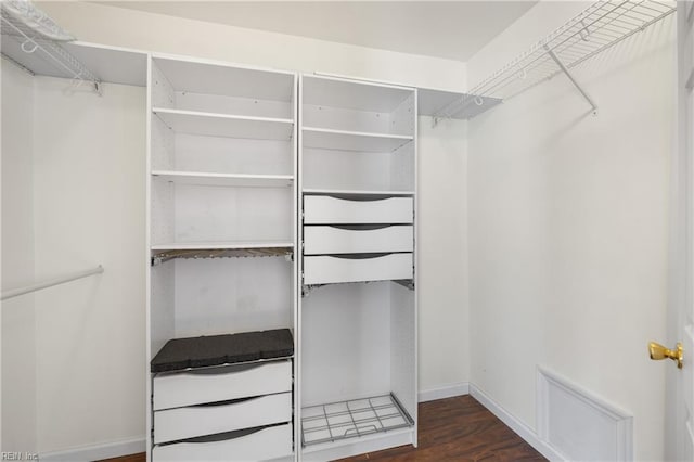 walk in closet with dark wood-type flooring