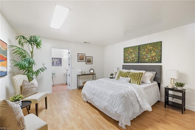 bedroom featuring ensuite bathroom and hardwood / wood-style floors