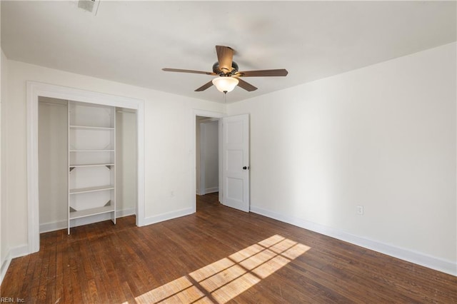 unfurnished bedroom with ceiling fan, dark hardwood / wood-style floors, and a closet