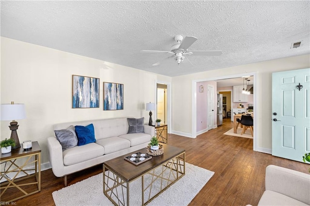 living room featuring a textured ceiling, ceiling fan, and dark hardwood / wood-style flooring