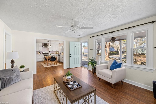 living room featuring ceiling fan, dark hardwood / wood-style floors, and a textured ceiling