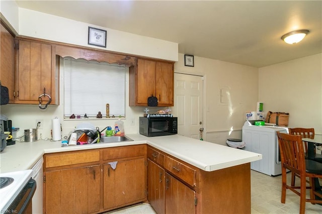 kitchen with electric range, kitchen peninsula, and washer / clothes dryer