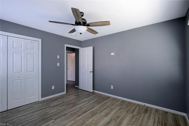 unfurnished bedroom featuring wood-type flooring, a closet, and ceiling fan