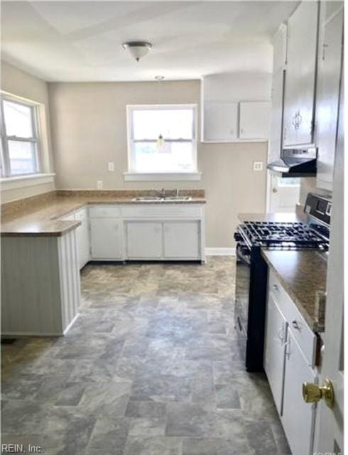 kitchen featuring sink, white cabinetry, stainless steel gas range, and a wealth of natural light