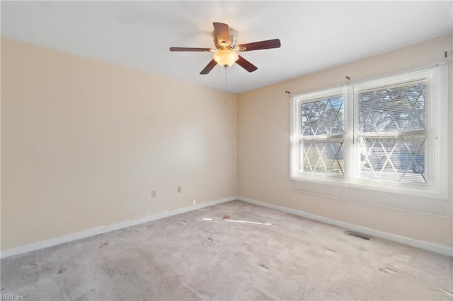 carpeted spare room featuring ceiling fan