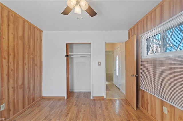 unfurnished bedroom featuring ceiling fan, a closet, and light wood-type flooring