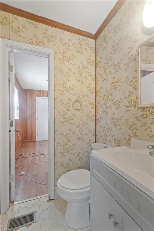 bathroom featuring toilet, crown molding, and vanity