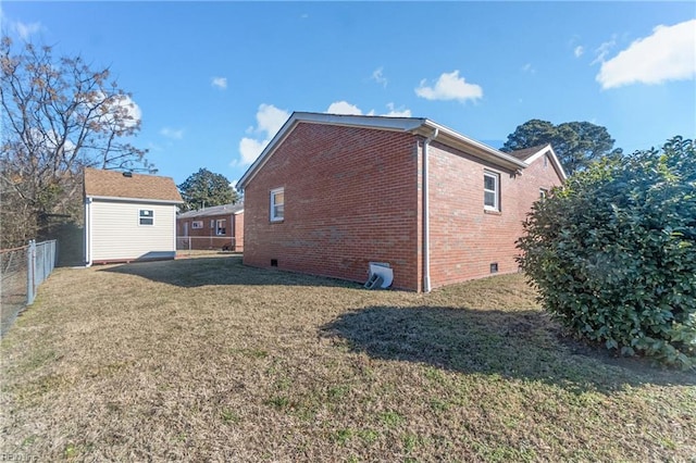 view of side of property featuring a shed and a yard