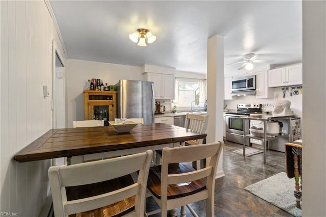 dining space featuring ceiling fan and sink