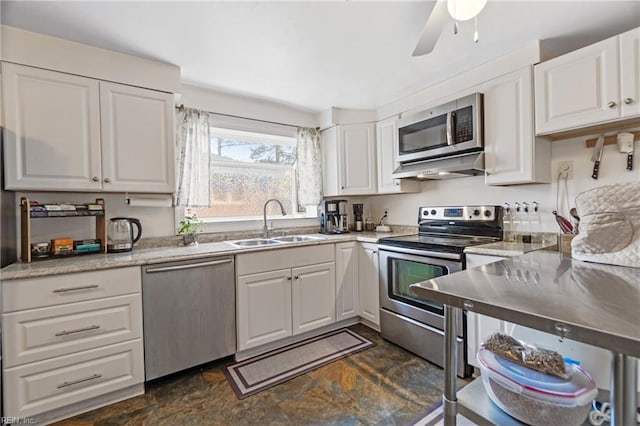 kitchen featuring stainless steel appliances, sink, white cabinets, ceiling fan, and light stone countertops