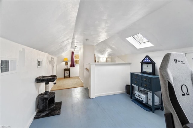 bonus room featuring lofted ceiling with skylight and light hardwood / wood-style flooring