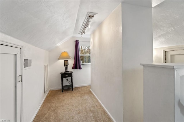 corridor with lofted ceiling and light colored carpet