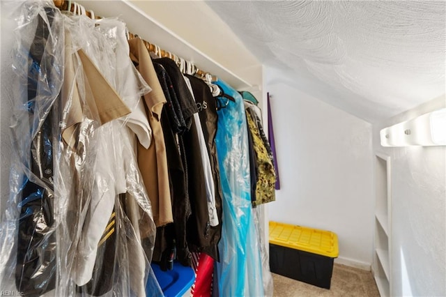 walk in closet with lofted ceiling and carpet floors