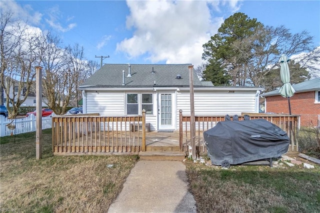 rear view of house with a lawn and a wooden deck