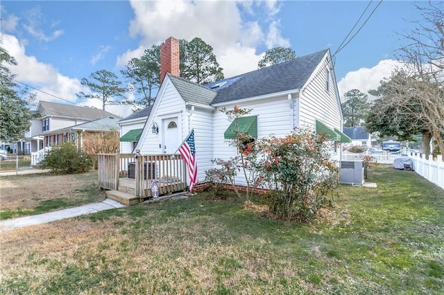 view of front of house featuring central AC and a front yard