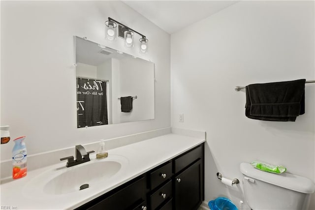 bathroom with toilet, vanity, and curtained shower