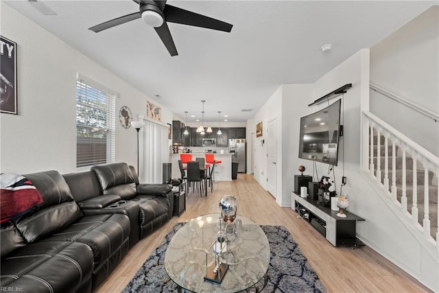 living room with light hardwood / wood-style floors and ceiling fan