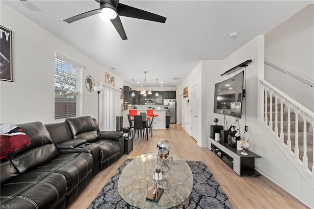 living room with light hardwood / wood-style floors and ceiling fan