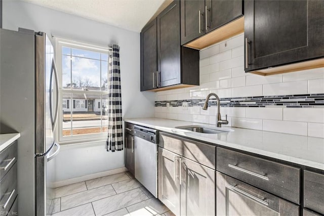 kitchen with sink, appliances with stainless steel finishes, tasteful backsplash, and dark brown cabinetry