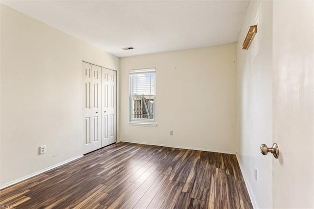 unfurnished room featuring dark wood-type flooring