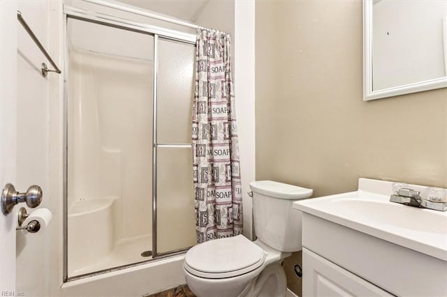 bathroom with toilet, a shower with shower door, and vanity