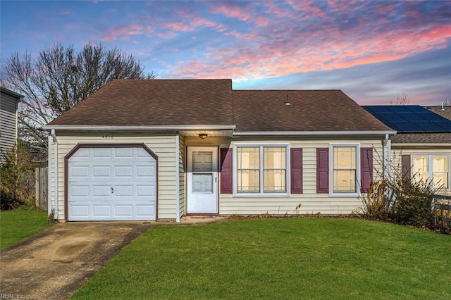 view of front of home with solar panels, a lawn, and a garage