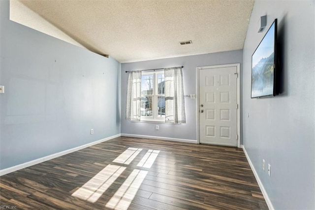 interior space featuring dark hardwood / wood-style flooring and a textured ceiling