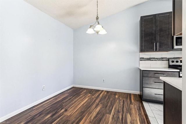 unfurnished dining area with hardwood / wood-style floors, vaulted ceiling, and a chandelier