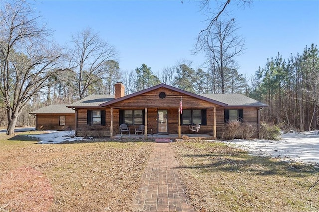 single story home with covered porch and a front yard