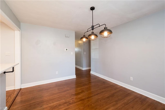 unfurnished dining area featuring dark wood-type flooring